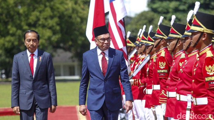 Presiden Joko Widodo dan Perdana Menteri Malaysia Anwar Ibrahim melambaikan tangan kepada wartawan saat bertemu di istana kepresidenan di Bogor, Jawa Barat, Senin (9/1/2023).