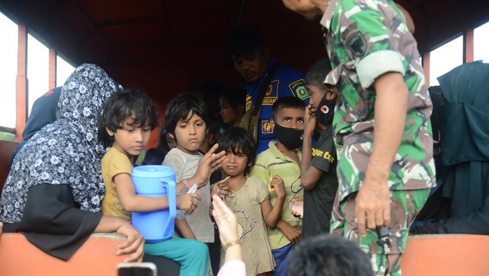 Personil Polri mengamankan sejumlah imigran etnis Rohingya terdampar di pantai desa Kampung Baru, Kecamatan Masjid Raya, Kabupaten Aceh, Besar, Aceh, Minggu (8/1/2023). Sebanyak 184 imigran etnis Rohingya terdiri dari sebanyak 69 laki laki dewasa, 75 perempuan dewasa, dan 40 anak anak terdampar di pantai Kabupaten Aceh Besar. ANTARA FOTO/Ampelsa/YU