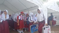 Siswa SDN Citamiang membawa meja belajar untuk ikuti pembelajaran di tenda