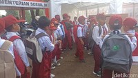 Siswa SDN Citamiang berbaring menunggu pemasangan terpal untuk alas belajar di hari pertama sekolah