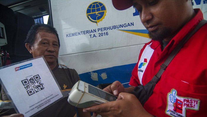 Wali Kota Palu Hadianto Rasyid (tengah) menyaksikan petugas memindai kode batang (QR Code) milik sopir truk sebelum mengisi solar subsidi di sebuah Stasiun Pengisian Bahan Bakar Umum (SPBU) di Palu, Sulawesi Tengah, Senin (9/1/2023). Setelah melakukan uji coba di Palu sebagai kota pilot project di Sulawesi, PT Pertamina Patra Niaga terhitung Senin (9/1) mulai memberlakukan kewajiban pemindaian kode batang kepada setiap kendaraan yang akan mengisi BBM jenis solar bersubsidi dan melakukan pembatasan-pembatasan jumlah pengisian sesuai jenis kendaraan. ANTARA FOTO/Basri Marzuki/hp.