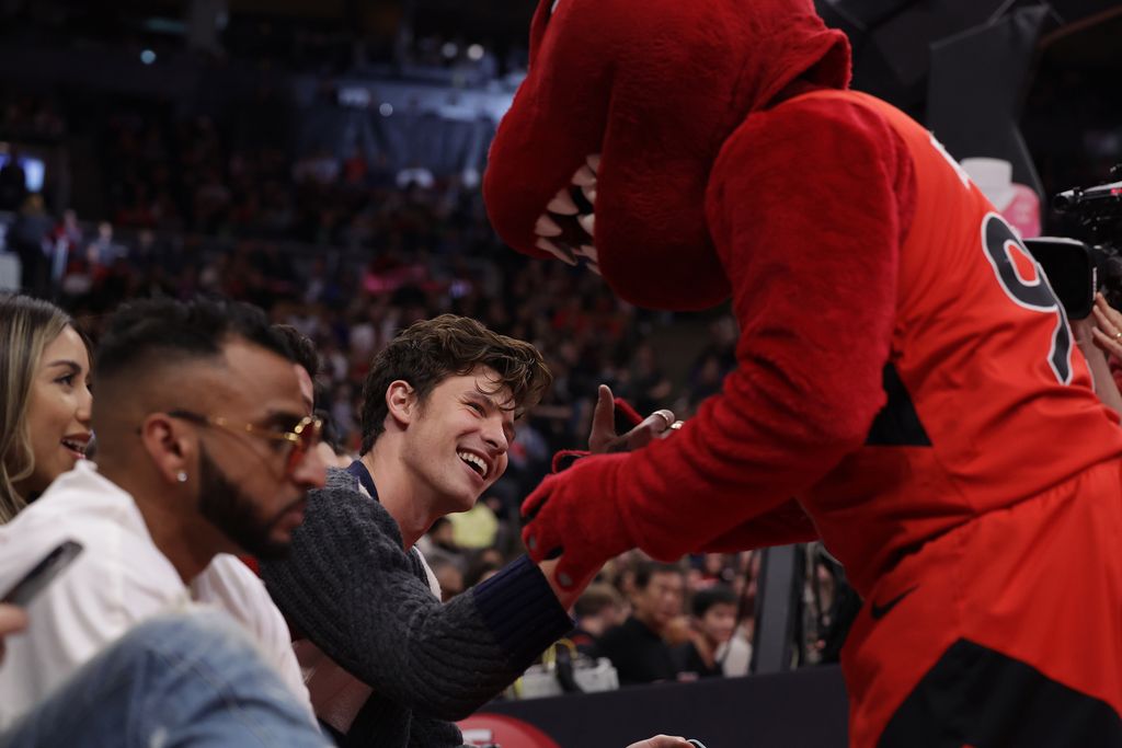 TORONTO, ON- DECEMBER 14  - Shawn Mendes is greeted by Toronto Raptors mascot The Raptor (95) as the Toronto Raptors play the Sacramento Kings at Scotiabank Arena in Toronto. December 14, 2022.        (Steve Russell/Toronto Star via Getty Images)