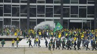 Tampak para perusuh mendobrak pintu dan jendela untuk memasuki gedung kongres.