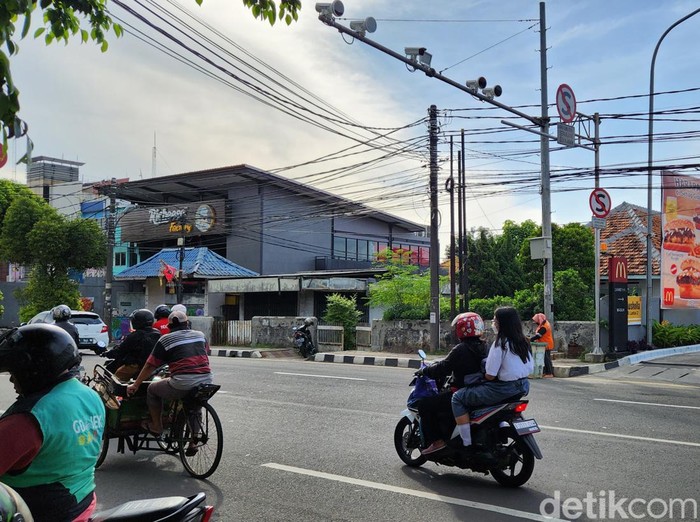 Para pengendara motor tanpa mengenakan helm melintas di bawah kamera tilang elektronik (E-TLE) di Jl Daan Mogot, Kota Tangerang, Banten (10/1/2023).