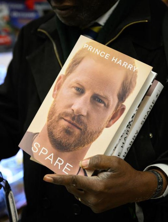 LONDON, ENGLAND - JANUARY 10: A man prepares to take a selfie as he holds copies of Spare by Prince Harry as they go on sale at one minutes after midnight in WH Smith bookstore at Victoria Station on January 10, 2023 in London, England. Prince Harrys memoir Spare, released on Tuesday, is already No 1 in the Amazon bestseller charts and one of the biggest pre-order titles for high-street retailers. (Photo by Leon Neal/Getty Images)
