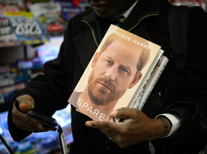 LONDON, ENGLAND - JANUARY 10: A man prepares to take a selfie as he holds copies of Spare by Prince Harry as they go on sale at one minutes after midnight in WH Smith bookstore at Victoria Station on January 10, 2023 in London, England. Prince Harrys memoir Spare, released on Tuesday, is already No 1 in the Amazon bestseller charts and one of the biggest pre-order titles for high-street retailers. (Photo by Leon Neal/Getty Images)