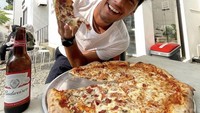 Makan seloyang pizza dengan aneka topping ditemani sebotol bir dingin jadi pilihan bersantapnya. Foto: Instagram @richo_kyle