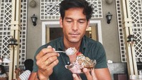 Saat berkunjung ke Surabaya, tentunya dirinya tak melewatkan kesempatan untuk makan es krim jadul yang ada di sana. Ia memesan banana split. Foto: Instagram @richo_kyle