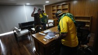Sejumlah demonstran memeriksa isi salah satu ruangan di gedung kongres Brasil.
