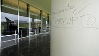 Tampak tulisan Parlemen Korup ditulis demonstran di dinding gedung kongres.