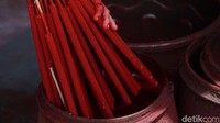 Pekerja mencelupkan hio dupa dengan pewarna merah.   
