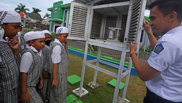 Petugas Badan Meteorologi, Klimatologi, dan Geofisika (BMKG) Serang menjelaskan cara kerja alat pengukur suhu udara kepada murid Sekolah Dasar yang melakukan studi lapangan di Laboratorium Terbuka BMKG di Serang, Banten, Senin (9/1/2023). Kegiatan tersebut bertujuan mengenalkan gejala perubahan iklim dan dampaknya bagi manusia kepada para murid. ANTARA FOTO/Asep Fathulrahman/hp.