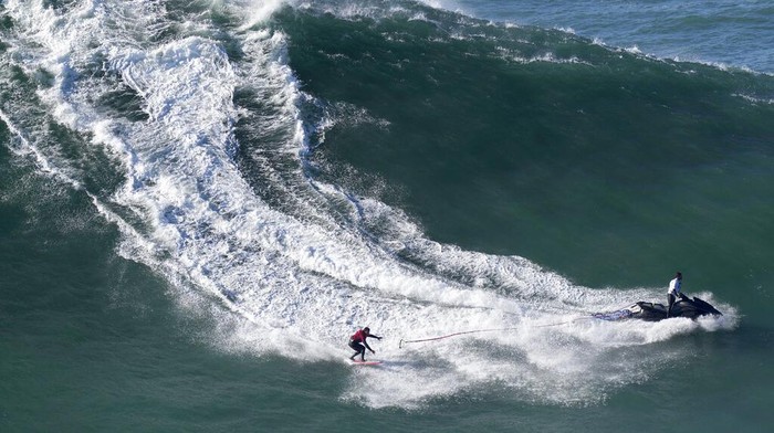 Skimboarding world champion Lucas Fink rides a wave at Praia do Norte, or North Beach, in Nazare, Portugal, Monday, Jan. 9, 2023. (AP Photo/Armando Franca)