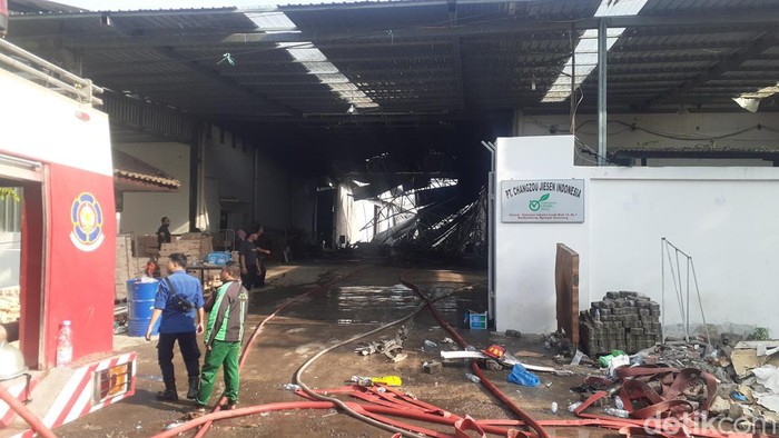 Petugas Damkar melakukan pendinginan di pabrik pengolah kayu yang terbakar di Kawasan Industri Candi, Semarang, Selasa (10/1/2023).