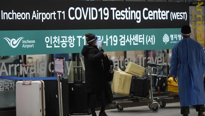 FILE - A woman arriving from China enters a COVID-19 testing center at the Incheon International Airport In Incheon, South Korea, Thursday, Jan. 5, 2023. China suspended visas Tuesday for South Koreans to come to the country for tourism or business in apparent retaliation for COVID-19 testing requirements on Chinese travelers. (AP Photo/Lee Jin-man, File)