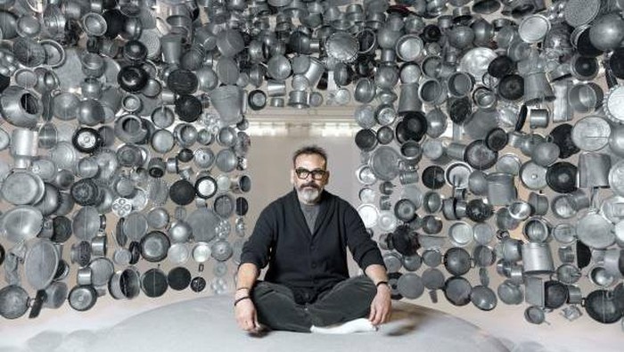 Unik Banget! Seniman Ini Bikin Gubuk dari Panci Masak Indian artist Subodh Gupta poses in one of his installations, a hanging hut made with cooking pots collected from markets during his exhibition entitled