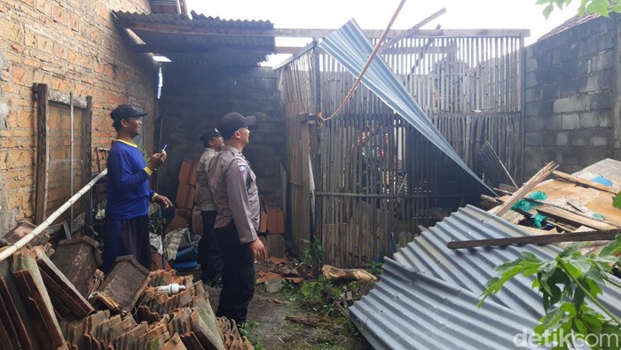 Warga bersama petugas bergotong royong membersihkan puing atap rumah yang rusak akibat puting beliung, Boyolali, Selasa (10/1/2023).
