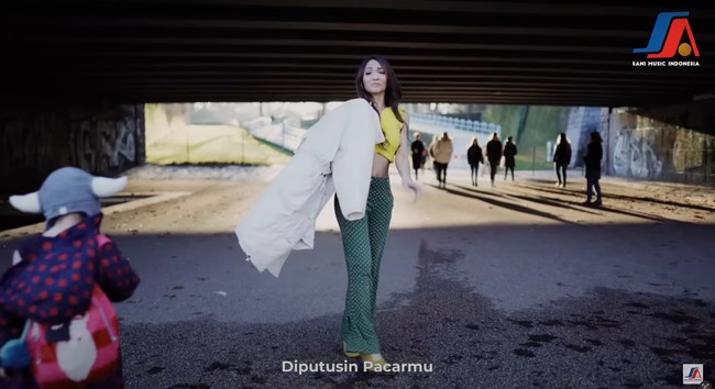 Penampilan Bunda Corla tampak paling nyentrik dan berbeda dari orang-orang yang berlalu lalang di jalanan kota Jerman. Meski sudah berusia 48 tahun namun penampilannya masih terlihat seperti ABG bukan? Foto: YouTube/Sani Music Indonesia