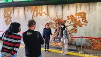 Banyak warga yang berhenti sejenak untuk foto-foto dengan latar belakang mural 3D.