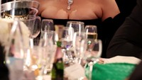 Selain itu ada Rihannya yang tampil cantik dengan gaun hitam. Ia pun disuguhkan dengan berbagai minuman di atas mejanya. Foto: Getty Images