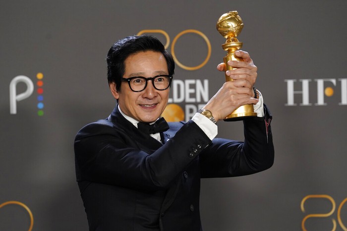 Ke Huy Quan poses in the press room with the award for best performance by an actor in a supporting role in any motion picture for 