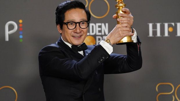 Ke Huy Quan poses in the press room with the award for best performance by an actor in a supporting role in any motion picture for 