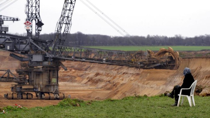 Climate activists sit in so-called tripos at village Luetzerath near Erkelenz, Germany, Tuesday, Jan. 10, 2023. The village of Luetzerath is occupied by climate activists fighting against the demolishing of the village to expand the Garzweiler lignite coal mine near the Dutch border. Poster read: „1,5 degrees celsius means: Luetzerath stays