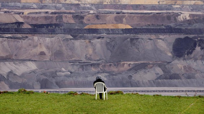 Kerja Keras Aktivis Iklim di Jerman Hentikan Perluasan Tambang Climate activists sit in so-called tripos at village Luetzerath near Erkelenz, Germany, Tuesday, Jan. 10, 2023. The village of Luetzerath is occupied by climate activists fighting against the demolishing of the village to expand the Garzweiler lignite coal mine near the Dutch border. Poster read: „1,5 degrees celsius means: Luetzerath stays