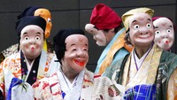 Seniman yang mengenakan topeng badut tradisional Jepang berbaris selama Festival Konpira di kuil Kotohiragu di distrik bisnis Toranomon Tokyo, Selasa (10/1/2023).
