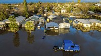 Setelah hujan berhari-hari, banjir menggenangi rumah dan kendaraan di komunitas Planada di Merced County, California. Badai juga memaksa ribuan orang untuk mengungsi. AP/Noah Berger  