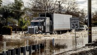 Sebuah truk berusaha menerobos banjir di Merced, California, saat badai terus menghantam negara bagian itu. AP/Noah Berger  