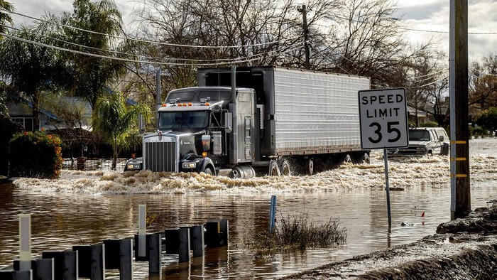 A truck drives through floodwaters in Merced, Calif., as storms continue battering the state on Tuesday, Jan. 10, 2023. (AP Photo/Noah Berger)