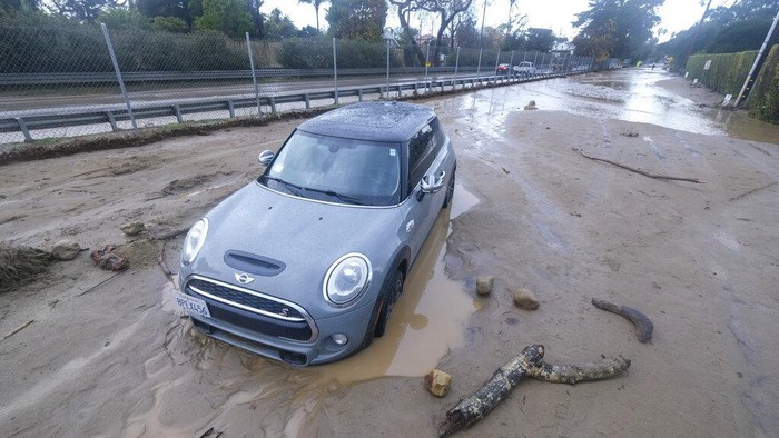 A vehicle is trapped by mud and debris at Jameson Lane near Highway 101 in Montecito, Calif., Tuesday, Jan. 10, 2023. (AP Photo/Ringo H.W. Chiu)