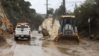 Pekerja CalTrans menghancurkan batu besar yang jatuh di Malibu Canyon Road di Malibu, California, AS, 10 Januari 2023.