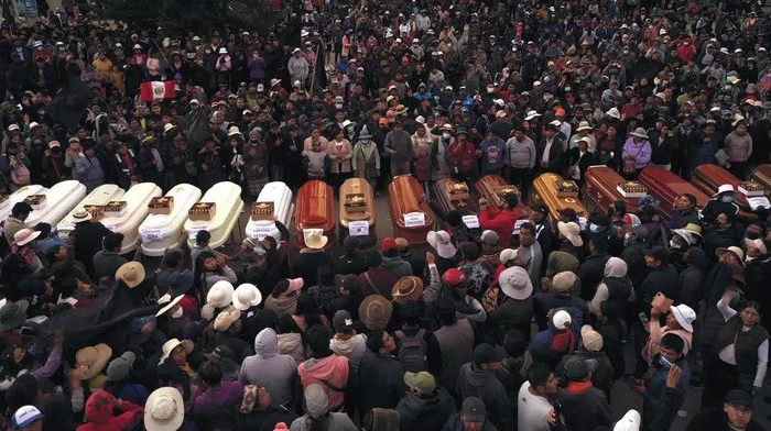 Residents surround coffins during a vigil for the more than a dozen people who died during the unrest in Juliaca, Peru, Tuesday, Jan. 10, 2023. At least 17 people died Monday in southeast Peru as protests seeking immediate elections resumed in neglected rural areas of the country still loyal to ousted President Pedro Castillo. (AP Photo/Jose Sotomayor)