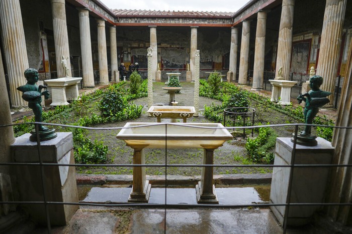 Colums frame the peristylium, or courtyard, in the center of the Ancient Roman Domus Vettiorum, House of Vettii, in the Pompeii Archeological Park, near Naples, southern Italy, Wednesday, Dec. 14, 2022. One of Pompeiis most famous and richest domus, which contains exceptional works of art and tells the story of the social ascent of two former slaves, is opening its doors to visitors Wednesday, Jan. 11, 2023 after 20 years of restoration. (AP Photo/Andrew Medichini)