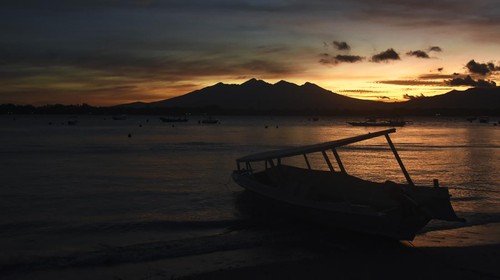 Siluet Gunung Rinjani terlihat saat matahari terbit (sunrise) di pantai Gili Trawangan, Desa Gili Indah, Kecamatan Pemenang, Tanjung, Lombok Utara, NTB, Rabu (11/1/2023). Gili Trawangan merupakan satu dari tiga pulau kawasan wisata Gili Tramena (Gili Trawangan, Gili Meno, Gili Air) yang saat ini mulai ramai dikunjungi kembali oleh wisatawan mancanegara setelah sepi akibat pandemi COVID-19. ANTARA FOTO/Ahmad Subaidi/aww.