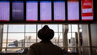 Penumpang melihat pengumuman keberangkatan yang tertunda di Bandara Internasional Dallas-Fort Worth (DFW), di Dallas, Texas, Amerika Serikat, Rabu (11/1/2023) waktu setempat. (John Moore/Getty Images)