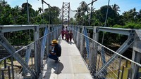 Seorang pekerja mengecat jembatan gantung yang baru dibangun di desa Siron Blang, Kecamatan Kuta Cot Glie, Aceh Besar, Rabu (11/1/2023).  