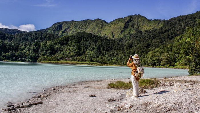 GARUT, INDONESIA - 2023/01/07: People enjoy the view of Talaga Bodas Crater in Garut. Talaga Bodas is a crater lake with white water caused by sulfur from Mount Talagabodas. This volcano is about 25 km east of the city of Garut and becomes one of the favorite tourist attractions in West Java. (Photo by Algi Febri Sugita/SOPA Images/LightRocket via Getty Images)