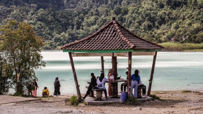 Kepincut Birunya Air di Talaga Bodas Garut GARUT, INDONESIA - 2023/01/07: People enjoy the view of Talaga Bodas Crater in Garut. Talaga Bodas is a crater lake with white water caused by sulfur from Mount Talagabodas. This volcano is about 25 km east of the city of Garut and becomes one of the favorite tourist attractions in West Java. (Photo by Algi Febri Sugita/SOPA Images/LightRocket via Getty Images)
