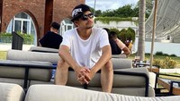 Momen Revaldo saat makan nongkrong di beach cafe. Ia duduk sambil menunggu pesanan makanan.