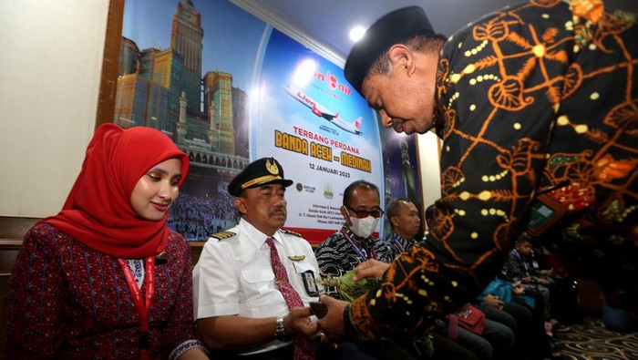 PENERBANGAN PERDANA BANDA ACEH-MADINAH Kepala Kantor Wilayah Kementerian Agama Aceh Iqbal (kanan) menepungtawari pramugari, pilot dan jamaah umrah pada pembukaan penerbangan perdana Banda Aceh - Madinah di Bandara Internasional Sultan Iskandar Muda, Aceh Besar, Aceh, Kamis (12/1/2023). Atas permintaan Pemerintah Aceh, maskapai Lion Air membuka layanan penerbangan internasional dari bandara Sultan Iskandar Muda tujuan Madinah setiap hari Kamis. ANTARA FOTO / Irwansyah Putra/aww.
