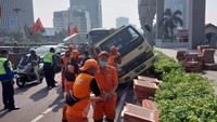 Truk kecelakaan menabrak pembatas jalur trotoar di samping Fly Over Kuningan Jalan Gatot Subroto menuju arah Semanggi. Saat ini sedang dalam proses evakuasi petugas. (Foto: Dok TMC Polda Metro)