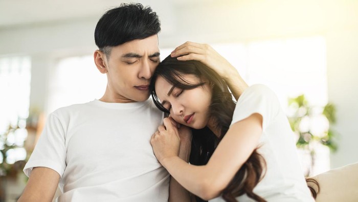 1315074289 Depressed young woman crying while her boylfriend come and embrace her