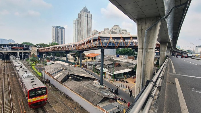 Commuter Line melintas di bawah jembatan penyeberangan orang (JPO) atau 
