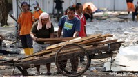 Warga membawa kayu-kayu untuk dimanfaatkan lagi.