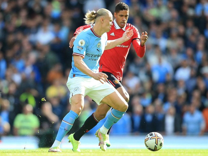 TOPSHOT - Manchester Citys Norwegian striker Erling Haaland (L) vies with Manchester Uniteds French defender Raphael Varane (R) during the English Premier League football match between Manchester City and Manchester United at the Etihad Stadium in Manchester, north west England, on October 2, 2022. - RESTRICTED TO EDITORIAL USE. No use with unauthorized audio, video, data, fixture lists, club/league logos or live services. Online in-match use limited to 120 images. An additional 40 images may be used in extra time. No video emulation. Social media in-match use limited to 120 images. An additional 40 images may be used in extra time. No use in betting publications, games or single club/league/player publications. (Photo by Lindsey Parnaby / AFP) / RESTRICTED TO EDITORIAL USE. No use with unauthorized audio, video, data, fixture lists, club/league logos or live services. Online in-match use limited to 120 images. An additional 40 images may be used in extra time. No video emulation. Social media in-match use limited to 120 images. An additional 40 images may be used in extra time. No use in betting publications, games or single club/league/player publications. / RESTRICTED TO EDITORIAL USE. No use with unauthorized audio, video, data, fixture lists, club/league logos or live services. Online in-match use limited to 120 images. An additional 40 images may be used in extra time. No video emulation. Social media in-match use limited to 120 images. An additional 40 images may be used in extra time. No use in betting publications, games or single club/league/player publications. (Photo by LINDSEY PARNABY/AFP via Getty Images)