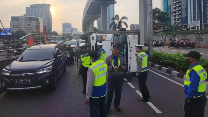 Polisi mengevakusi truk kecelakaan hingga terguling di Jalan Gatot Subroto, Jakarta Selatan (Jaksel). Lalu lintas arah Semanggi macet.