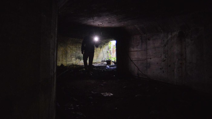Warga memotret pintu masuk benteng pertahanan Jepang yang terbengkelai di Ulak Karang, Padang, Sumatera Barat, Jumat (13/1/2023). Benteng pertahanan Jepang yang memiliki dua kamar dan satu ruangan pengintaian dengan panjang total 22 meter itu berpotensi dikembangkan menjadi objek wisata sejarah karena berada di dekat pantai.